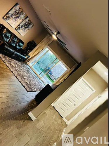 A living room with a couch and a painting on the wall.