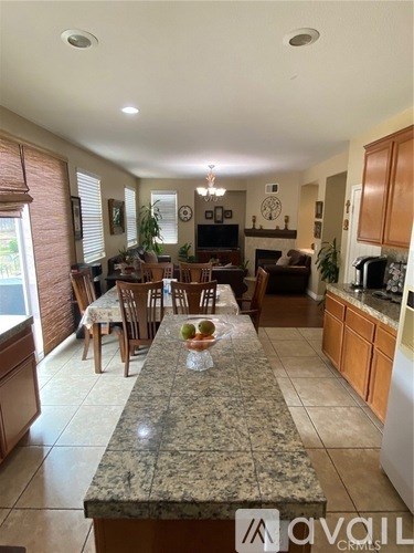 A kitchen with granite countertops and wooden cabinets.