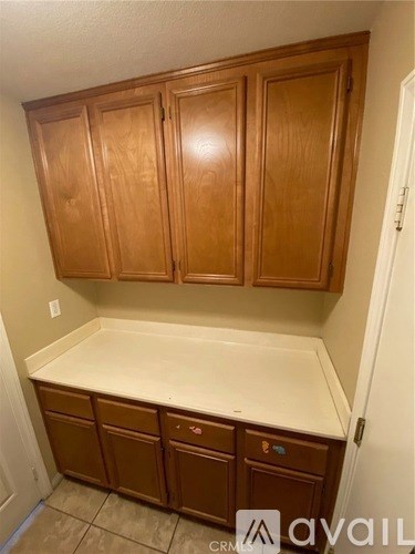 Brown cabinets above a counter in a room.