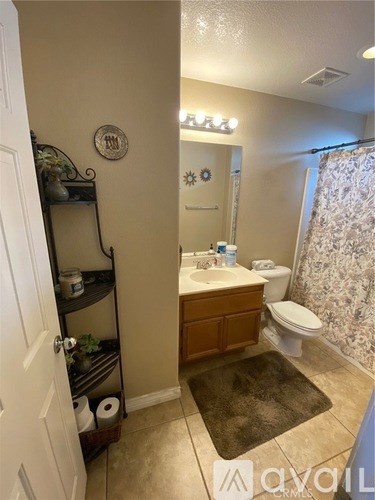 A bathroom with a toilet, sink, and a mirror.