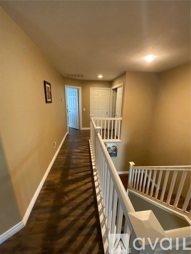 A hallway with a white railing on the right side.
