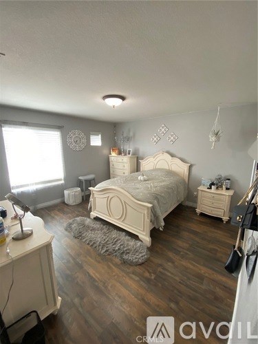 A bedroom with a large bed and wooden floors.
