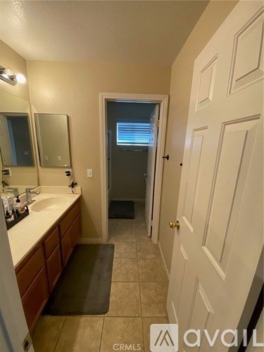 A bathroom with a sink, mirror, and a door.