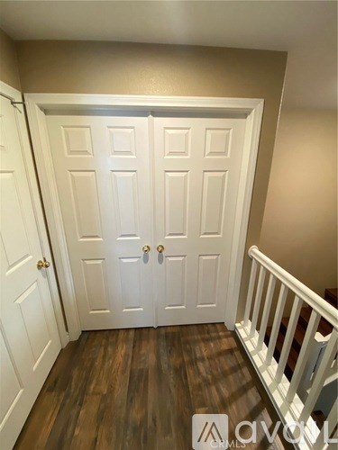A white double door with a wooden floor and a white railing.