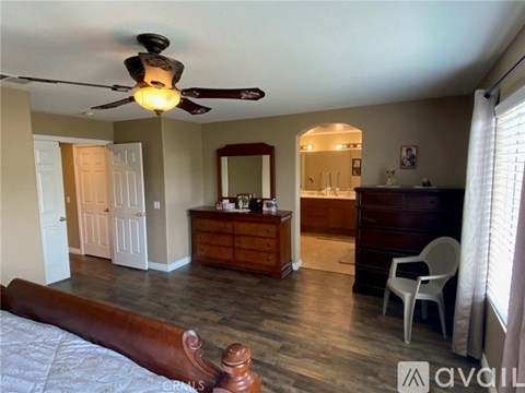 A bedroom with a bed, dresser, mirror, and chair.