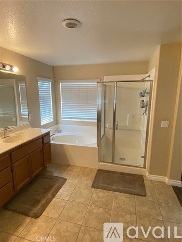 A bathroom with a glass shower door and a sink.