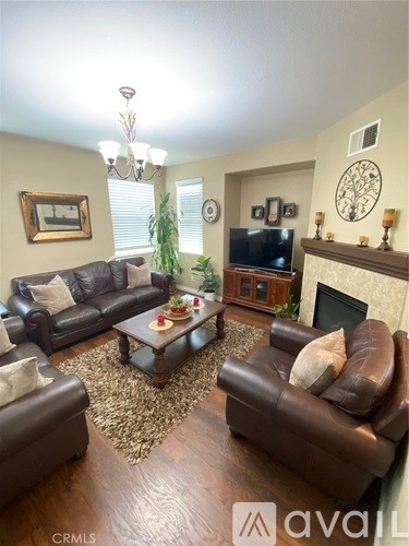A living room with brown leather furniture and a fireplace.