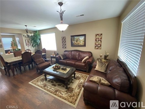 A living room with brown leather furniture and a rug.