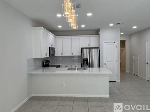 A kitchen with white cabinets and a white island with a sink.