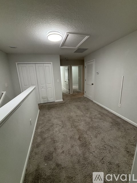 A carpeted hallway with a door on the left and a door on the right.