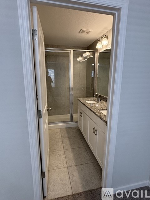 A bathroom with a sink, mirror, and shower.
