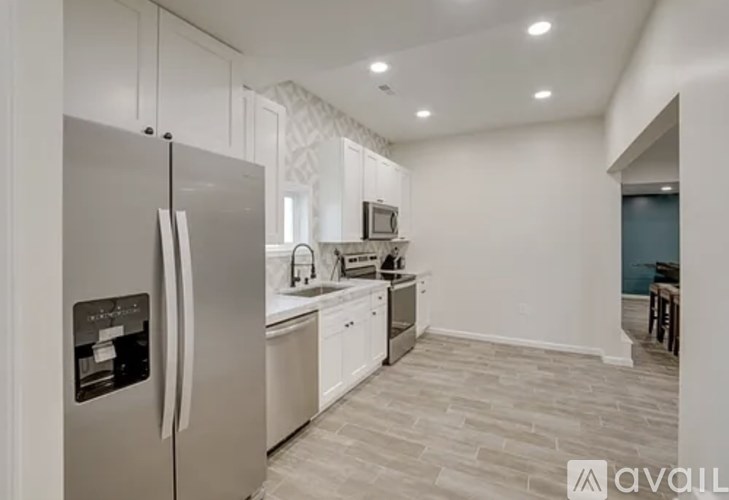 A modern kitchen with a refrigerator, sink, and countertops.