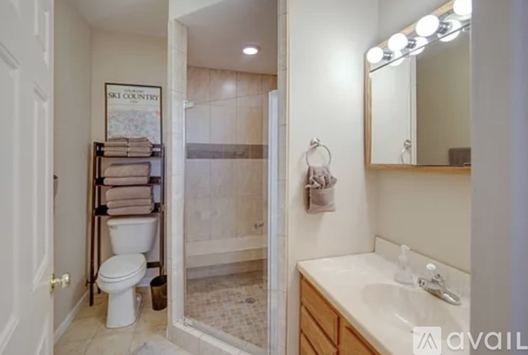 A bathroom with a toilet, sink, and mirror.