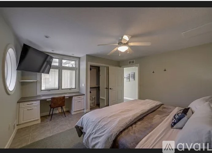 A bedroom with a bed, desk, and chair.