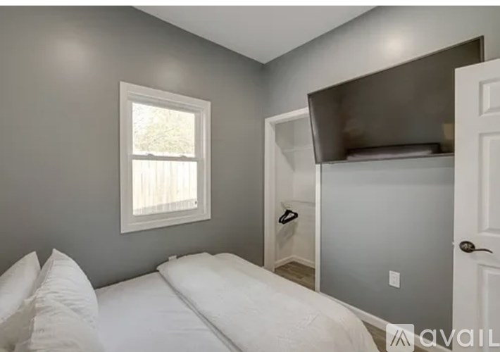 A bedroom with a bed, a window, and a closet.