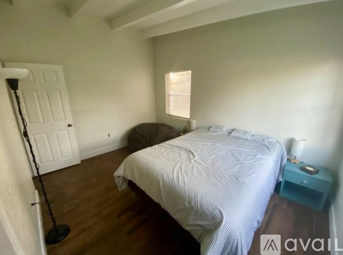 A bedroom with a bed, nightstand, and lamp.