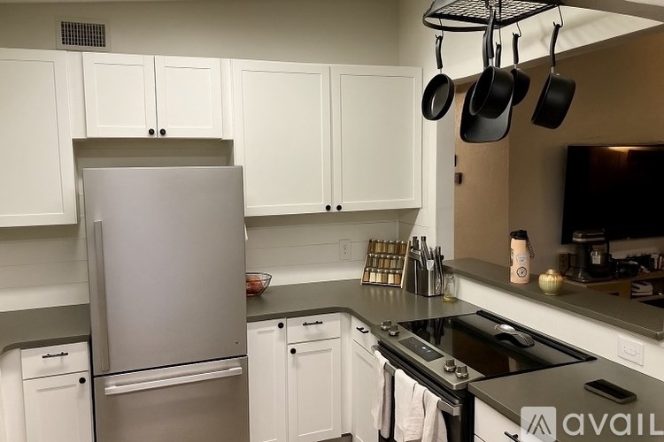 A kitchen with white cabinets and a stainless steel refrigerator.