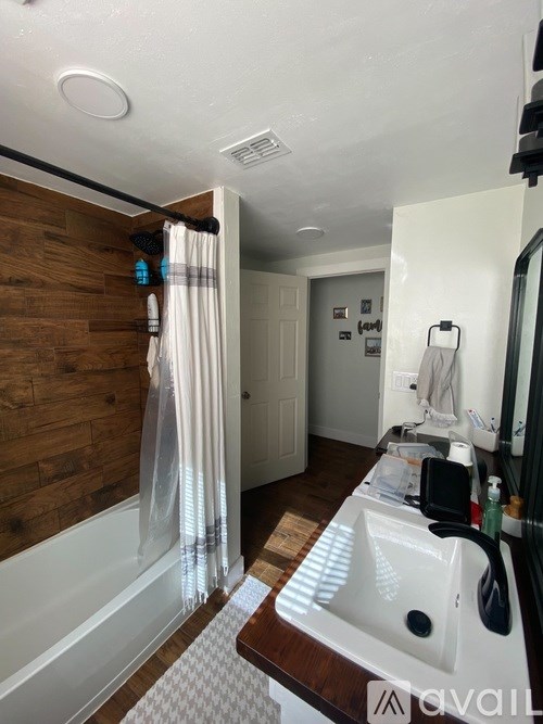 A bathroom with a white sink and a wooden wall.