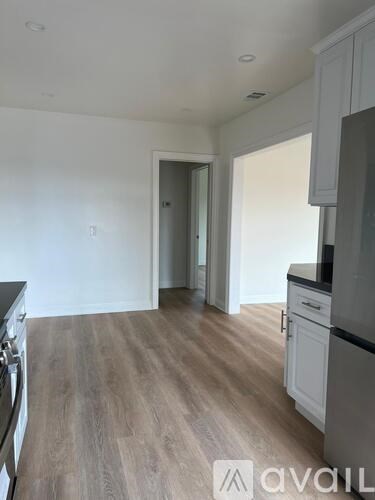 A kitchen with a wooden floor and white walls.