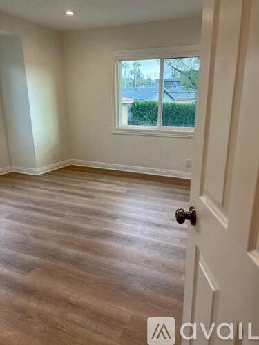 A room with a wooden floor and a white door.