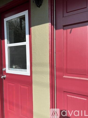 A red door with a window and a white frame.