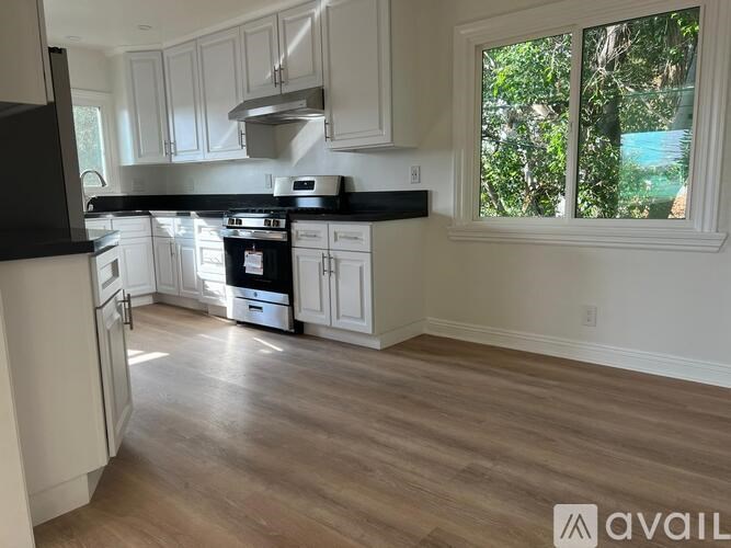 A kitchen with black countertops and white cabinets.
