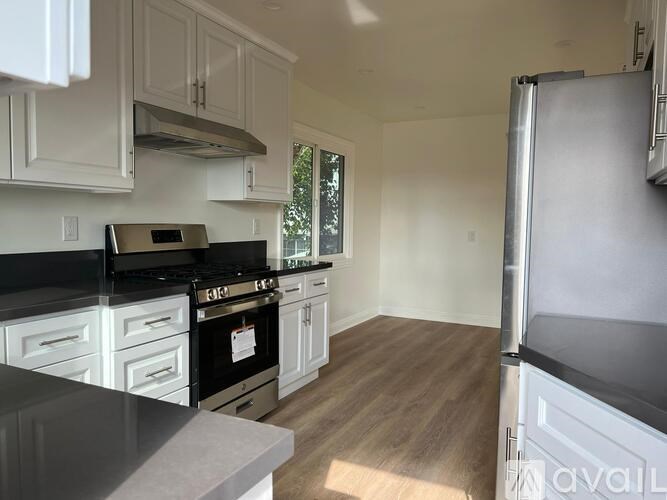 A kitchen with black appliances and white cabinets.
