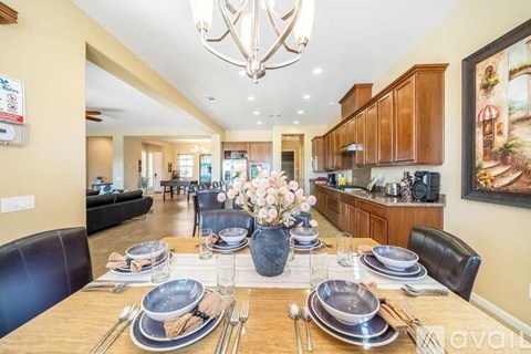 A dining room with a wooden table set for a meal.