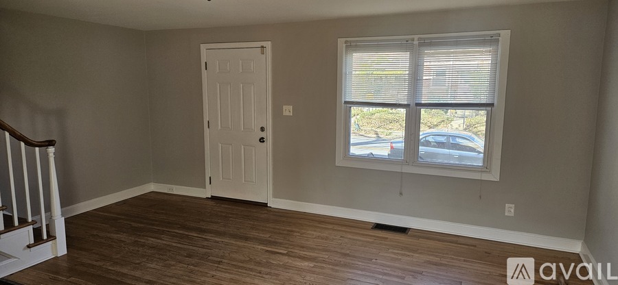 A room with a white door and a window with blinds.