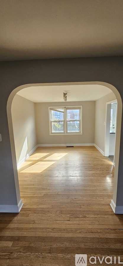 A room with wooden flooring and a window.