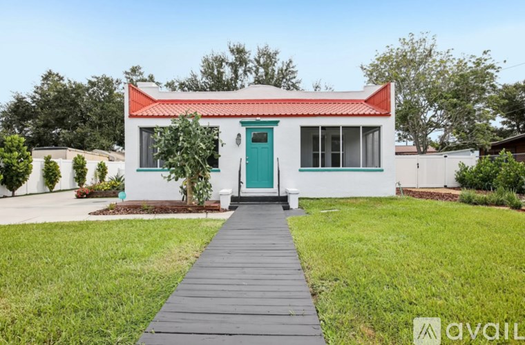A white house with a red roof and a green door.