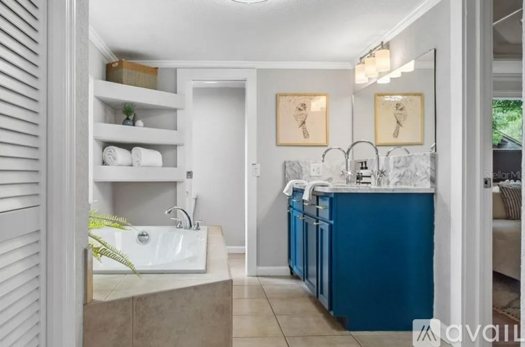 A bathroom with a white sink and a blue cabinet.