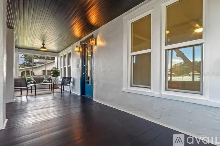 A wooden deck with a table and chairs is visible through a glass door.