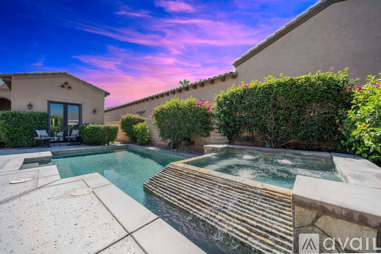 A house with a pool and a hot tub in the backyard.