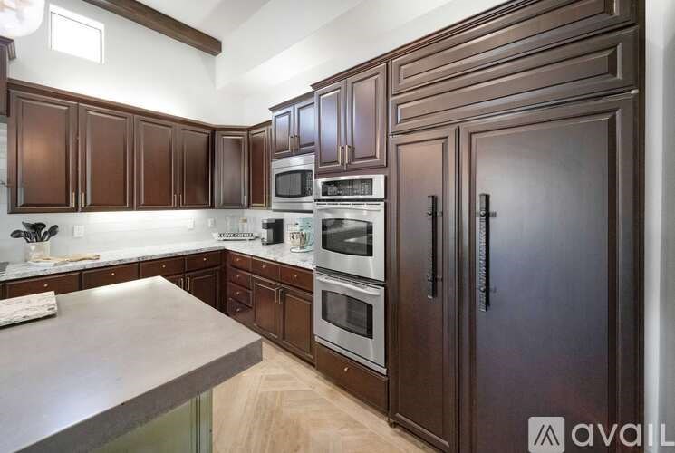 A kitchen with dark brown cabinets and stainless steel appliances.
