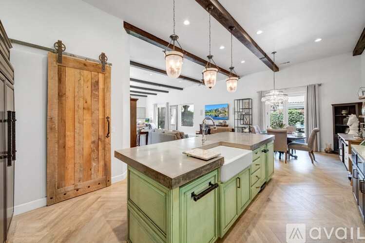 A kitchen with green cabinets and a wooden door.