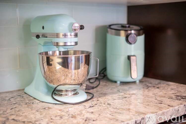 A blue kitchenaid mixer with a bowl on the counter.