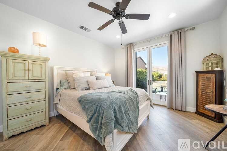 A bedroom with a bed, dresser, and ceiling fan.