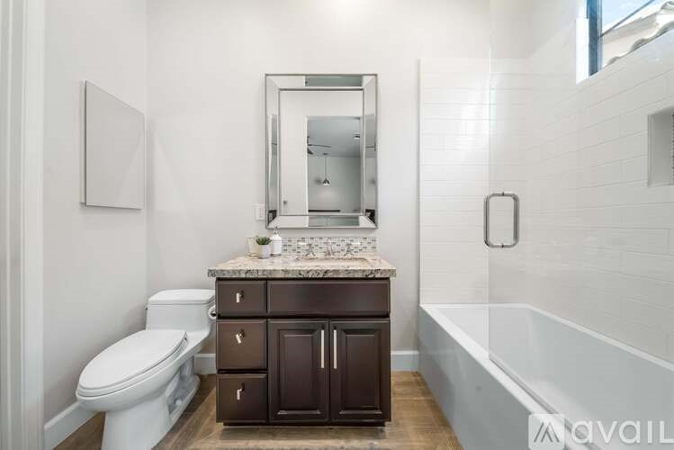 A white toilet sits next to a vanity with a mirror above it.
