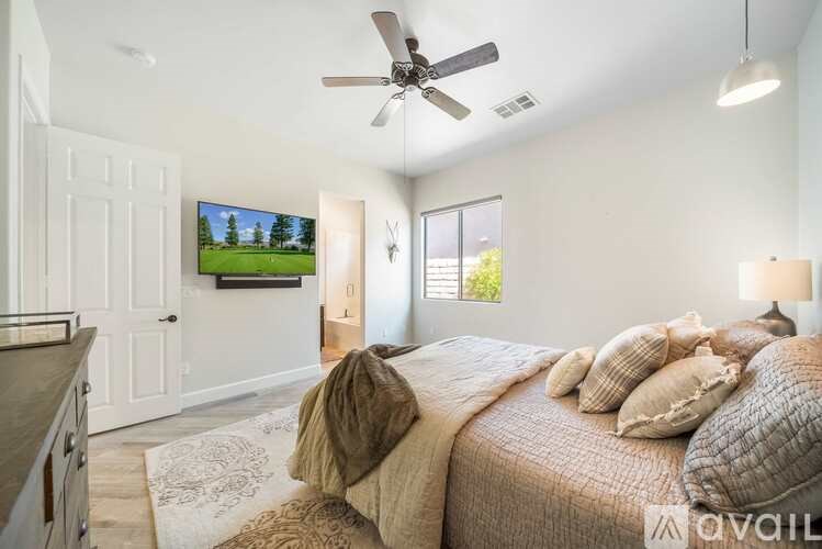 A bedroom with a large bed and a flat screen TV mounted on the wall.