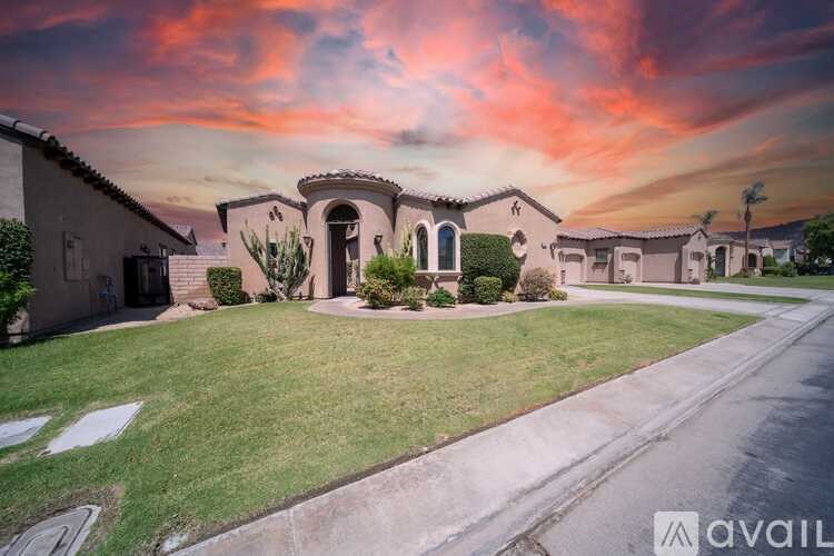 A house with a driveway and a front yard with a statue.