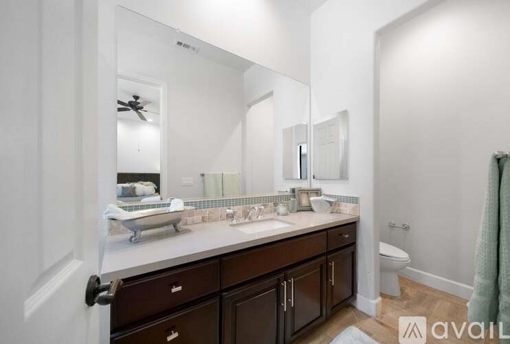A bathroom with a white countertop and brown cabinets.