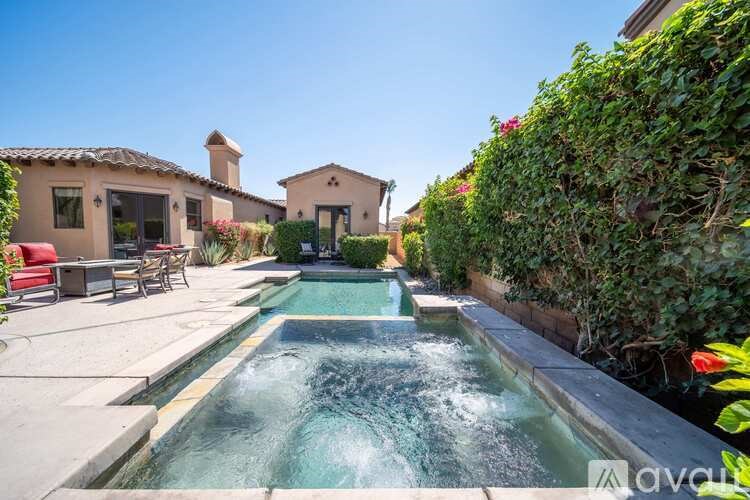 A small pool with a waterfall in the middle of a backyard.