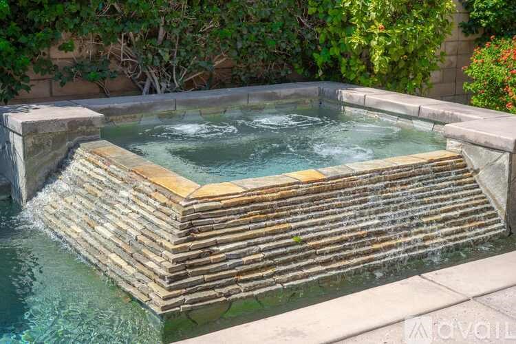 A hot tub with a waterfall feature in the middle.