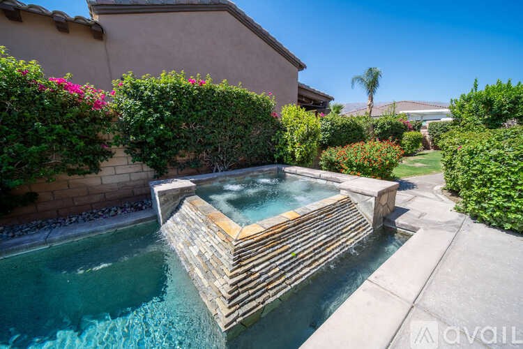 A pool with a wooden ledge and a wall with plants on it.