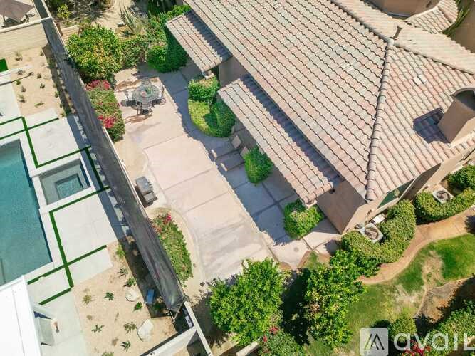 A house with a red tiled roof and a pool.