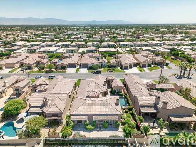 A bird's eye view of a residential neighborhood with houses and swimming pools.
