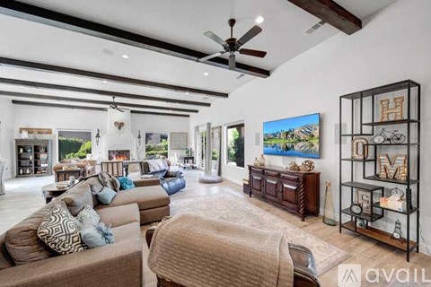 A spacious living room with a large couch and a painting on the wall.