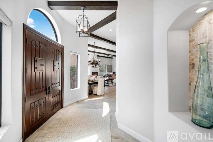 A modern interior with a wooden door and a glass vase on a shelf.