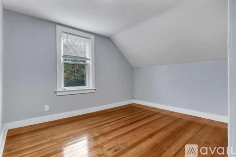 A room with wooden flooring and a window.